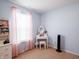 Bright bedroom with pastel blue walls, vanity table, and natural light from a window at 8125 Whistlewood Dr, Indianapolis, IN 46239