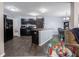 Modern kitchen with stainless steel appliances, dark cabinetry, an island, and open to the dining area at 8125 Whistlewood Dr, Indianapolis, IN 46239