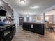 Open floor plan connecting kitchen and dining area, with dark cabinets and wood-look flooring throughout at 8125 Whistlewood Dr, Indianapolis, IN 46239