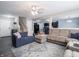 Open concept living room with plush sofas, a patterned rug, and seamless flow into dining and kitchen areas at 8125 Whistlewood Dr, Indianapolis, IN 46239