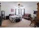 Tranquil primary bedroom with a ceiling fan, comfortable bed, and a cozy sitting area near sunlit windows at 8125 Whistlewood Dr, Indianapolis, IN 46239