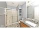 Bathroom featuring a shower with glass doors, vanity with granite countertop, and built-in shelving at 8909 Carnation Dr, Noblesville, IN 46060