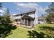 Back of home with a deck and screened-in porch, complemented by lush greenery and a large backyard at 8909 Carnation Dr, Noblesville, IN 46060