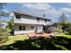 Exterior view of the home showcases a deck and screened-in porch in a well-manicured yard at 8909 Carnation Dr, Noblesville, IN 46060