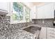 Close-up view of a kitchen sink, white cabinets, and granite countertops with a view from the window at 8909 Carnation Dr, Noblesville, IN 46060