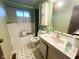 Bathroom featuring patterned wallpaper, black and white flooring, and white fixtures at 906 Hemlock St, Shelbyville, IN 46176