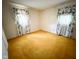 Bedroom with plush carpet flooring, two windows with floral print curtains at 906 Hemlock St, Shelbyville, IN 46176