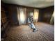 Spacious room with patterned carpet, wood paneled walls, large windows and an exercise bike at 906 Hemlock St, Shelbyville, IN 46176