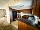Kitchen featuring wooden cabinets, black appliances, and views into the living room at 906 Hemlock St, Shelbyville, IN 46176