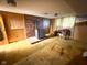 Living room featuring a wood burning stove, wood paneled walls, carpet and vintage light fixtures at 906 Hemlock St, Shelbyville, IN 46176