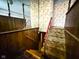 Hallway with a carpeted staircase, wood paneling and eye catching floral wallpaper and mirrored wall at 906 Hemlock St, Shelbyville, IN 46176