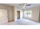 Bright bedroom showcasing a ceiling fan, carpeted floors and a window with a view of the neighborhood at 9404 Crystal River Dr, Indianapolis, IN 46240