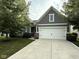 Charming home with a two-car garage, gray siding, a well-manicured lawn, and mature shade trees at 9404 Crystal River Dr, Indianapolis, IN 46240