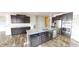 A modern kitchen features an island with a white countertop, stainless steel appliances, and dark cabinets at 9404 Crystal River Dr, Indianapolis, IN 46240