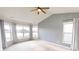 Spacious main bedroom featuring a ceiling fan, a vaulted ceiling and large windows overlooking the backyard at 9404 Crystal River Dr, Indianapolis, IN 46240