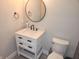 Charming powder room featuring a white vanity, round mirror, and modern black fixtures at 955 Dorman St, Indianapolis, IN 46202