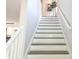 Bright staircase with white risers and railing, leading to upper level with natural light and modern design at 955 Dorman St, Indianapolis, IN 46202