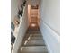 View looking down the wooden staircase with white risers and a handrail, with a curated art gallery on the wall at 955 Dorman St, Indianapolis, IN 46202