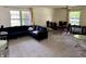 Bright and airy living room with neutral carpet, large windows, and a dark blue couch at 9621 Gemini Dr, Indianapolis, IN 46229