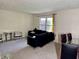 Cozy living room featuring a dark sofa, plush carpet, and natural light from the window at 9621 Gemini Dr, Indianapolis, IN 46229