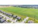 An aerial shot shows a suburban neighborhood with contemporary homes next to a lush green agricultural field at 9986 Gallop Ln, Fishers, IN 46040