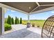 Relaxing covered patio with paver flooring, landscaping, and wicker chair, perfect for outdoor enjoyment at 9986 Gallop Ln, Fishers, IN 46040