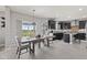 Open-concept dining area featuring stylish pendant lighting and views of the green outdoors at 9986 Gallop Ln, Fishers, IN 46040