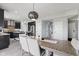 Contemporary dining room with modern light fixture, view to the kitchen, and hallway access at 9986 Gallop Ln, Fishers, IN 46040