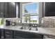 Stylish kitchen sink featuring modern fixtures, granite countertop, and dark wood cabinets at 9986 Gallop Ln, Fishers, IN 46040