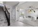 Open-concept living space with gray carpet and staircase at 9986 Gallop Ln, Fishers, IN 46040