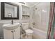 Well-lit bathroom with vanity, shelving unit, and tub-shower combo at 10155 Orchard Park W Dr, Carmel, IN 46280