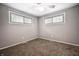 Cozy bedroom featuring soft carpet, two windows, and a ceiling fan at 10155 Orchard Park W Dr, Carmel, IN 46280