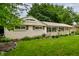 Quaint home featuring an attached garage and neatly landscaped front yard with decorative rock border and lush green grass at 10155 Orchard Park W Dr, Carmel, IN 46280