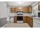 Kitchen featuring light oak cabinets, white appliances, and ample counter space at 10155 Orchard Park W Dr, Carmel, IN 46280