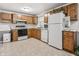 Spacious eat-in kitchen features oak cabinets, white appliances, and durable flooring at 10155 Orchard Park W Dr, Carmel, IN 46280