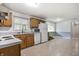 Traditional kitchen with oak cabinetry, white appliances, and a window view to the yard at 10155 Orchard Park W Dr, Carmel, IN 46280