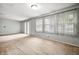 Sunlit living area featuring neutral carpet, vertical blinds, and large windows that brighten the space at 10155 Orchard Park W Dr, Carmel, IN 46280