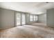 Spacious living room with natural light, sliding glass doors, and neutral-colored carpet at 10155 Orchard Park W Dr, Carmel, IN 46280