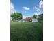 Backyard with a swimming pool, brick house, storage shed, and large green lawn at 1050 Laguna Ln, Greenwood, IN 46143