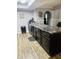 Close up view of kitchen island featuring black cabinetry, granite countertops, stylish sink and updated flooring at 1050 Laguna Ln, Greenwood, IN 46143