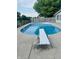 Backyard pool with diving board and fence surrounded by green trees at 1050 Laguna Ln, Greenwood, IN 46143