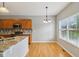 Bright dining area featuring hardwood floors, modern lighting, and an adjacent kitchen area at 1246 Valdosta Pl, Westfield, IN 46074