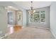 Light-filled dining room with carpet, chandelier, and large windows looking out onto the neighborhood at 1246 Valdosta Pl, Westfield, IN 46074