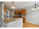 Well lit kitchen features granite countertops, a tile backsplash, hardwood flooring, and wood cabinets at 1246 Valdosta Pl, Westfield, IN 46074