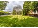 Wide shot of backyard and beautiful landscaping with lush green grass and a large tree at 14030 Old Mill Ct, Carmel, IN 46032