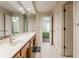 Bright bathroom with a long vanity, large mirror, and access to the main bedroom at 14030 Old Mill Ct, Carmel, IN 46032