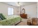 Bedroom featuring a four-poster bed, ceiling fan, and wood dresser with mirror at 14030 Old Mill Ct, Carmel, IN 46032