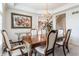 Elegant dining room with hardwood table and seating for six under a beautiful chandelier at 14030 Old Mill Ct, Carmel, IN 46032