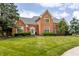 Beautiful brick home with a well-maintained lawn and mature trees in a suburban setting at 14030 Old Mill Ct, Carmel, IN 46032