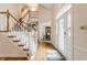 Elegant foyer features hardwood floors, a staircase with white railings, and decorative door at 14030 Old Mill Ct, Carmel, IN 46032